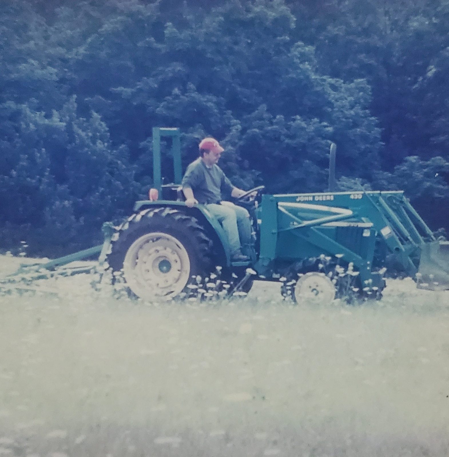 William Sargent mowing a field on a tractor